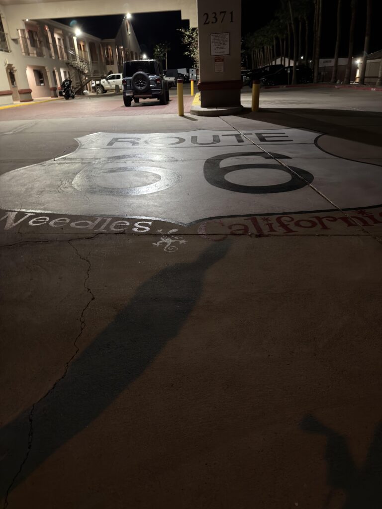 Route 66 Needles California auf den Boden gemalt bei Nacht mit Jeep im Hintergrund