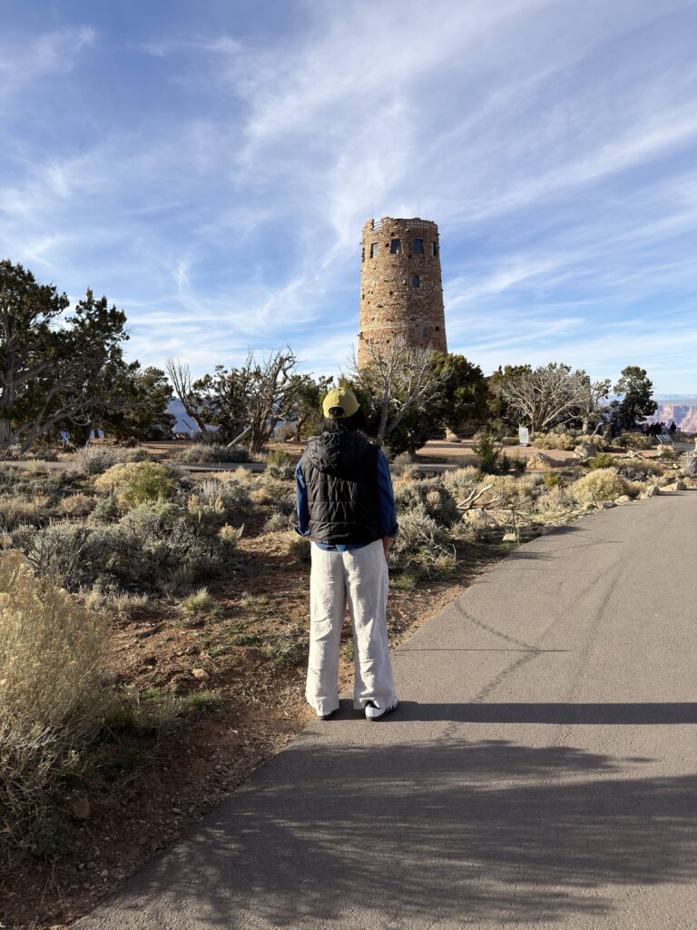 Frau steht vor dem Desert View Watchtower am Ostausgang des Grand Canyon