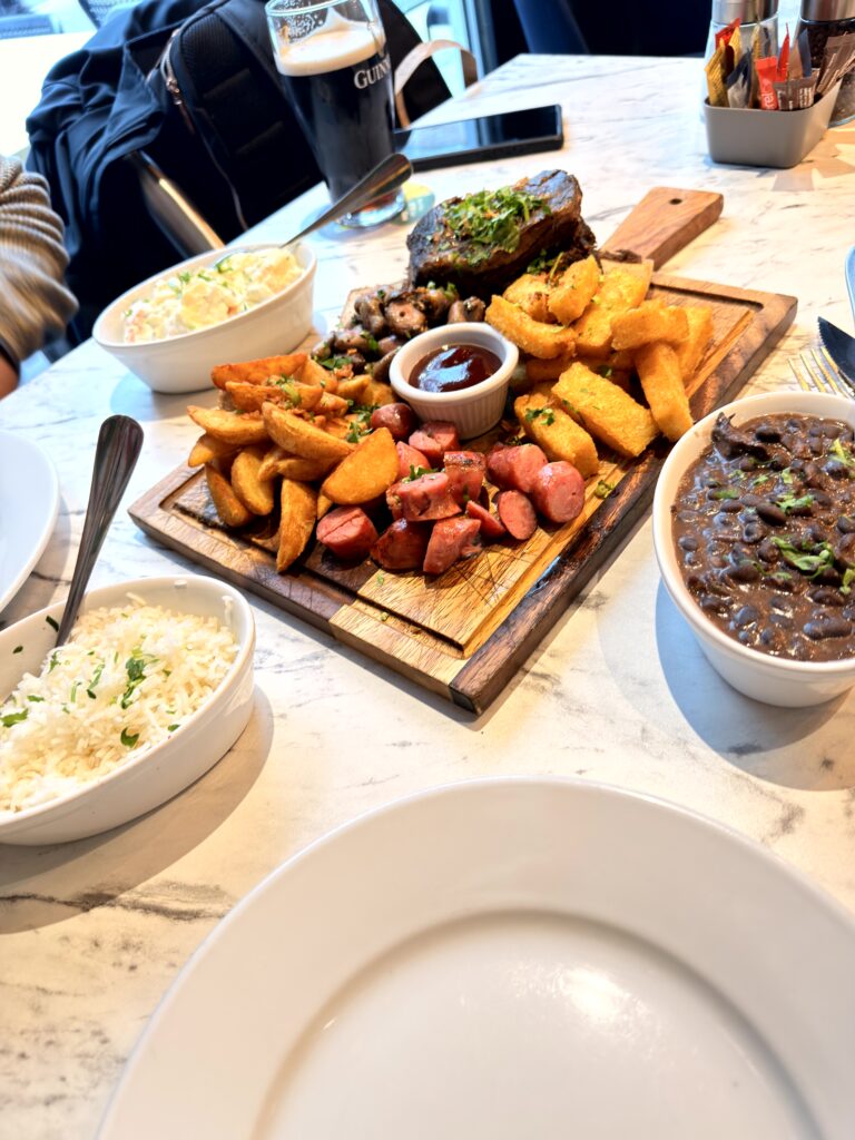 Mixed Grill Board bei The Ribs Dublin auf Marmortisch mit Beilagen Reis, Feijoada und Kartoffelsalat