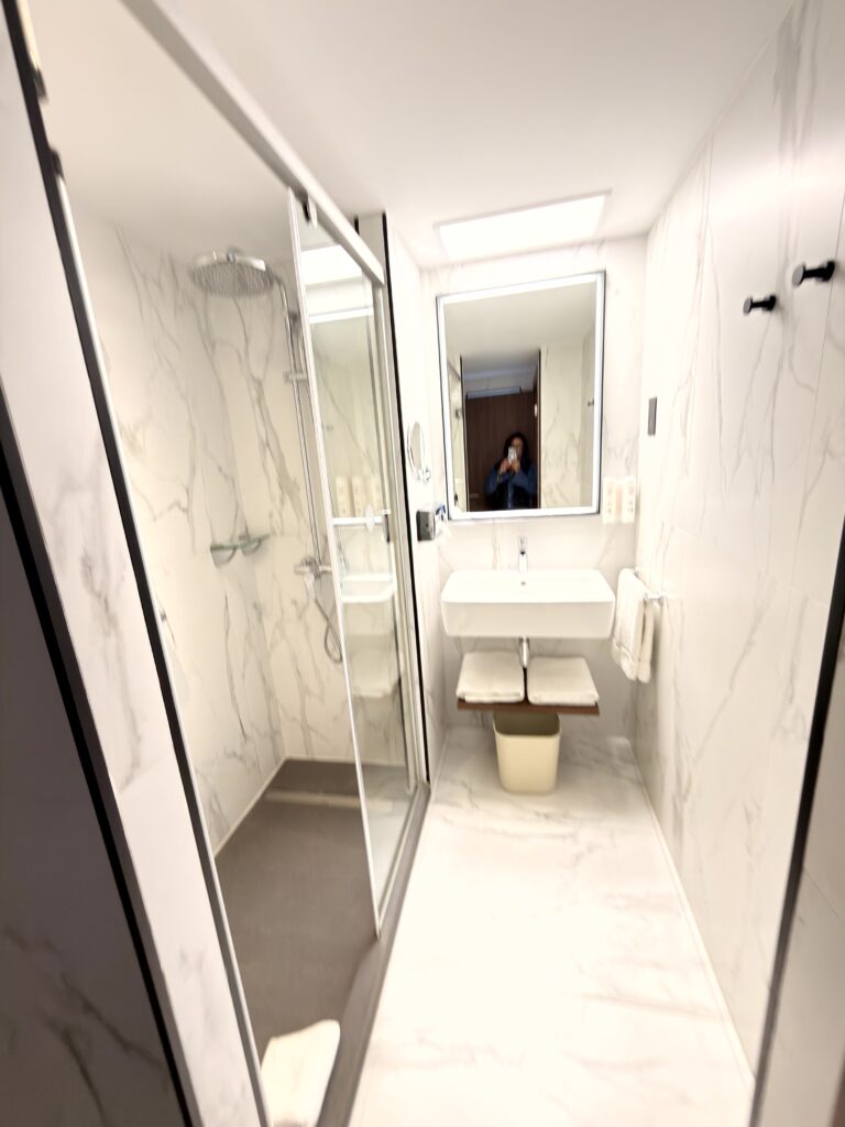 Modernes Badezimmer mit Regendusche und Marmorwänden im Riu Plaza The Gresham Dublin