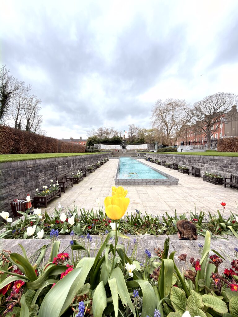 Garden of Remembrance in Dublin mit Wasserbecken, Tulpen und irischer Flagge im Hintergrund