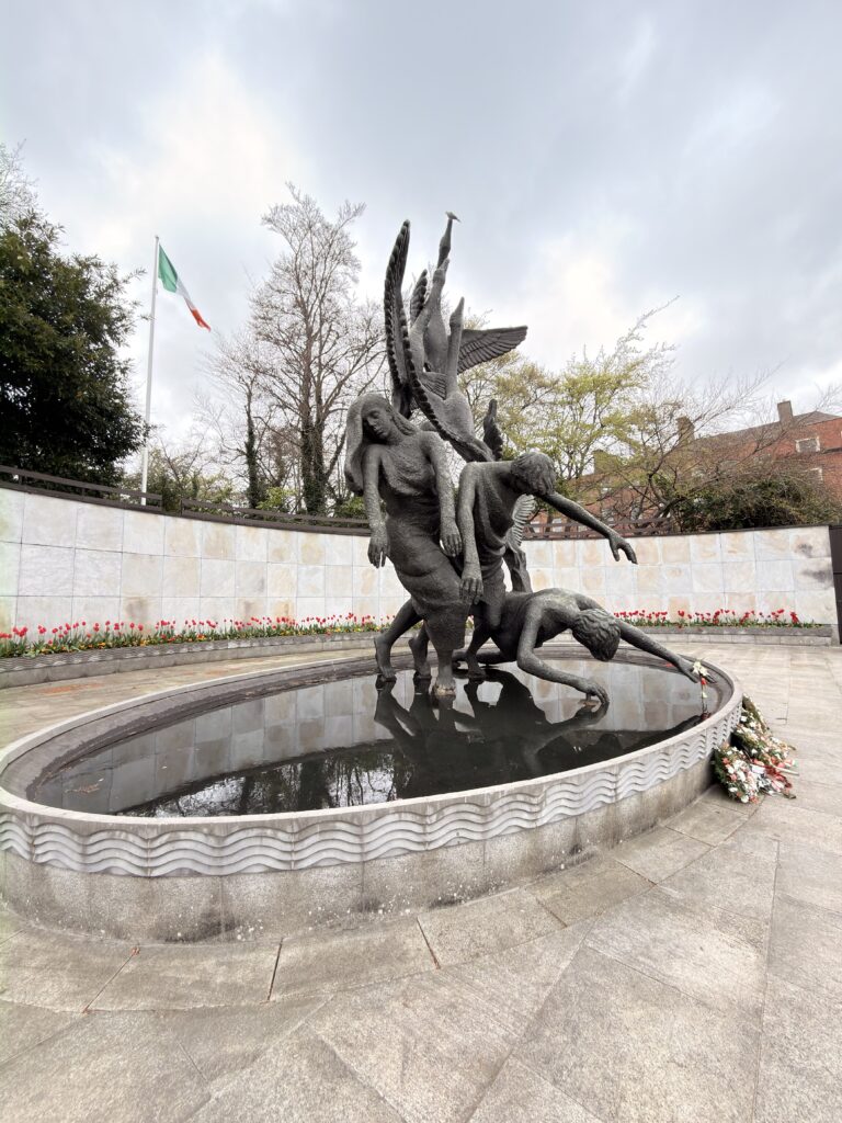 Bronzeskulptur Children of Lir im Wasserbecken des Garden of Remembrance Dublin mit irischer Flagge im Hintergrund