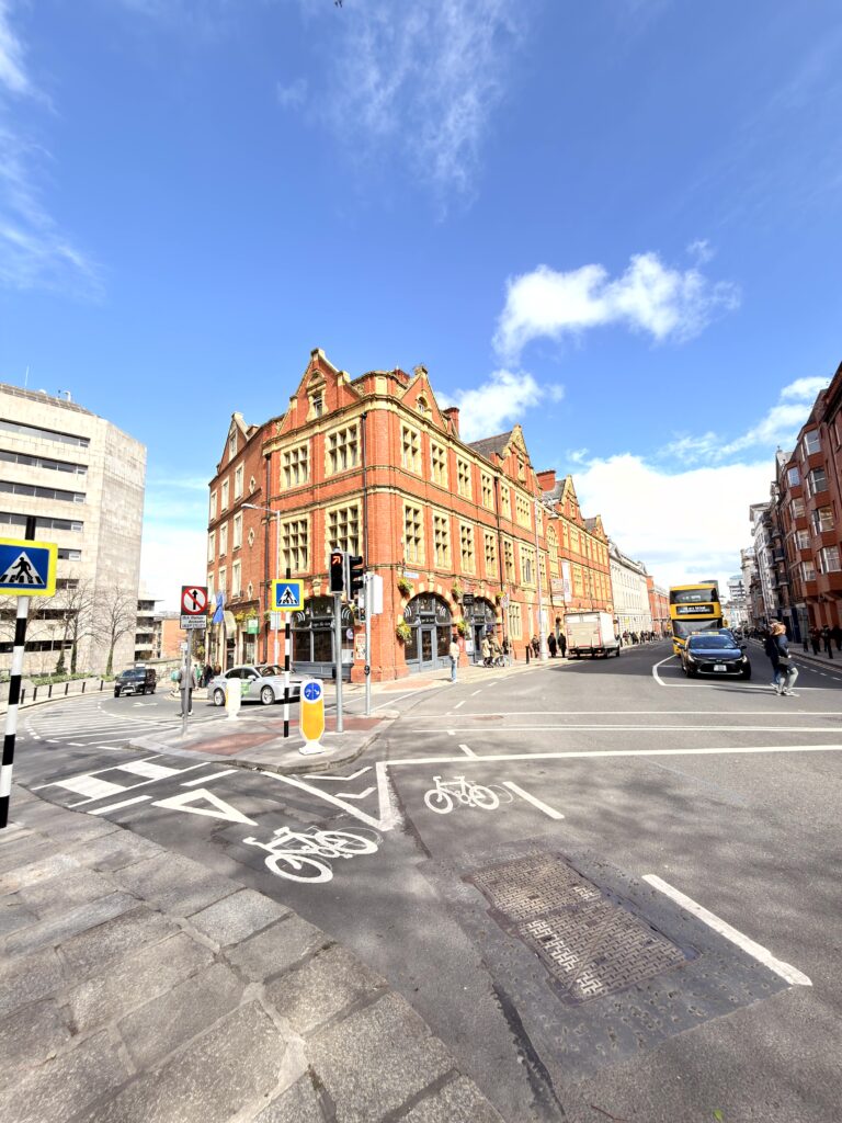 Viktorianisches Backsteingebäude an einer Straßenkreuzung in Dublin mit blauem Himmel