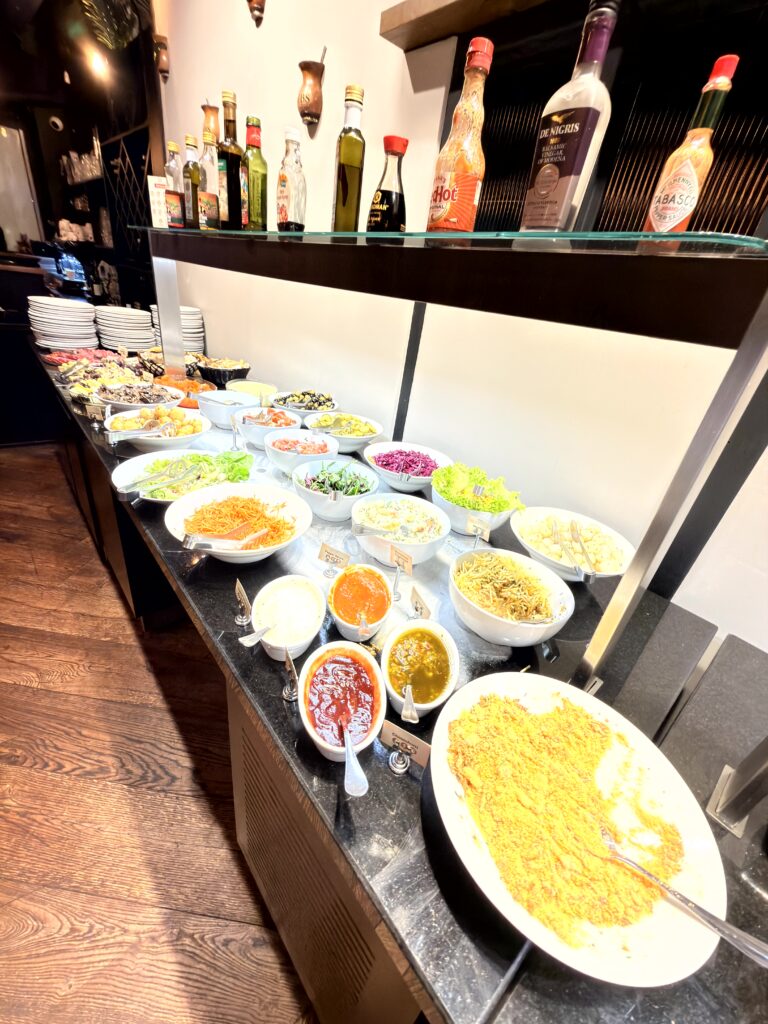 Moderner Innenraum des Restaurants The Ribs Dublin mit dunklen Samtsesseln und offener Küche