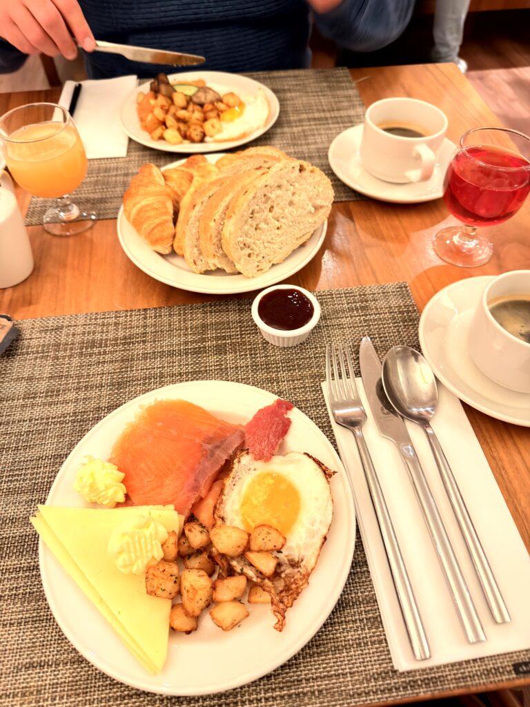 Reichhaltiges Frühstück mit Lachs, Spiegelei, Bacon, Bratkartoffeln, Ananas und Croissant im Riu Plaza The Gresham Dublin
