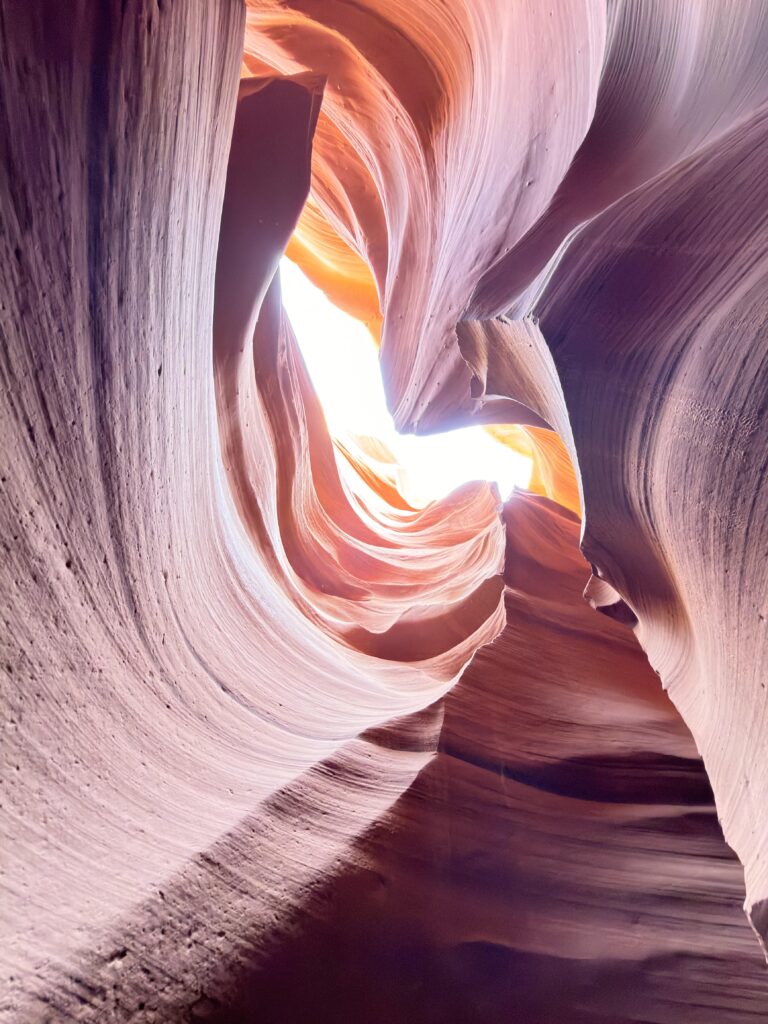 Enge, spiralförmig gewundene Sandsteinpassage im Lower Antelope Canyon mit Lichteinfall am Ende