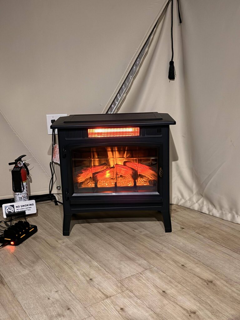 Elektrischer Kamin mit Flammeneffekt im Innenraum des Glamping-Zelts in Kanab, Utah
