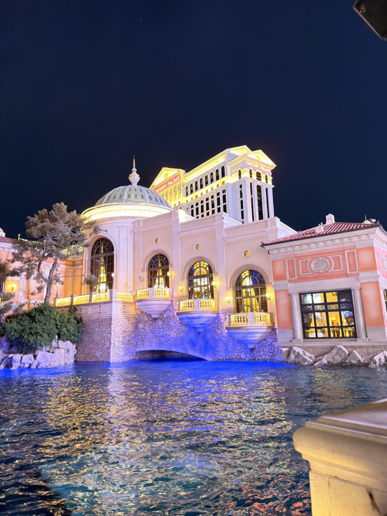 Beleuchtete Fassade des Caesars Palace mit blauem Wasserbecken in Las Vegas bei Nacht