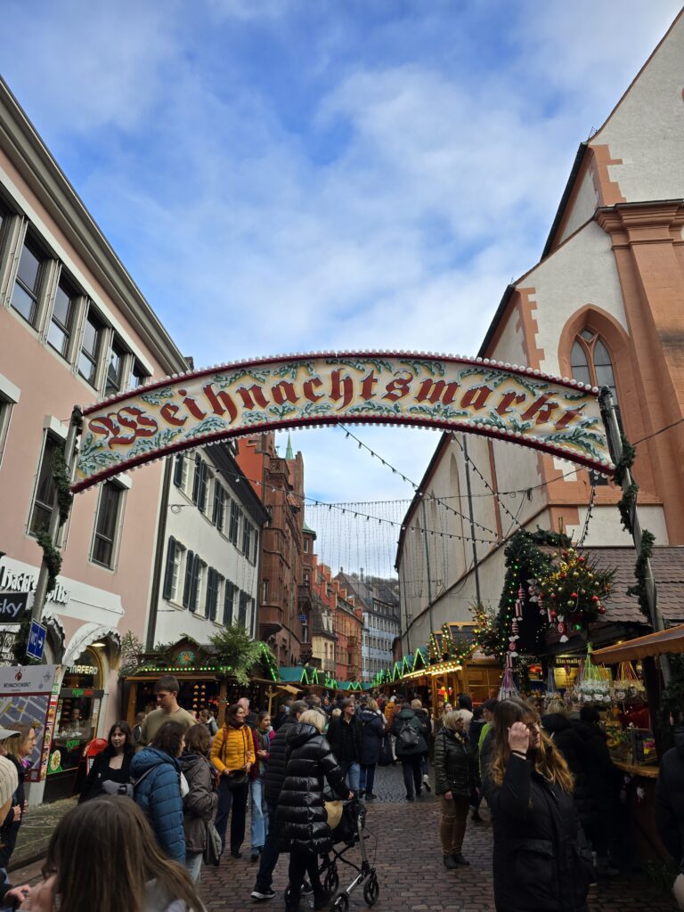 Eingang zum Weihnachtsmarkt Freiburg mit geschmücktem Torbogen