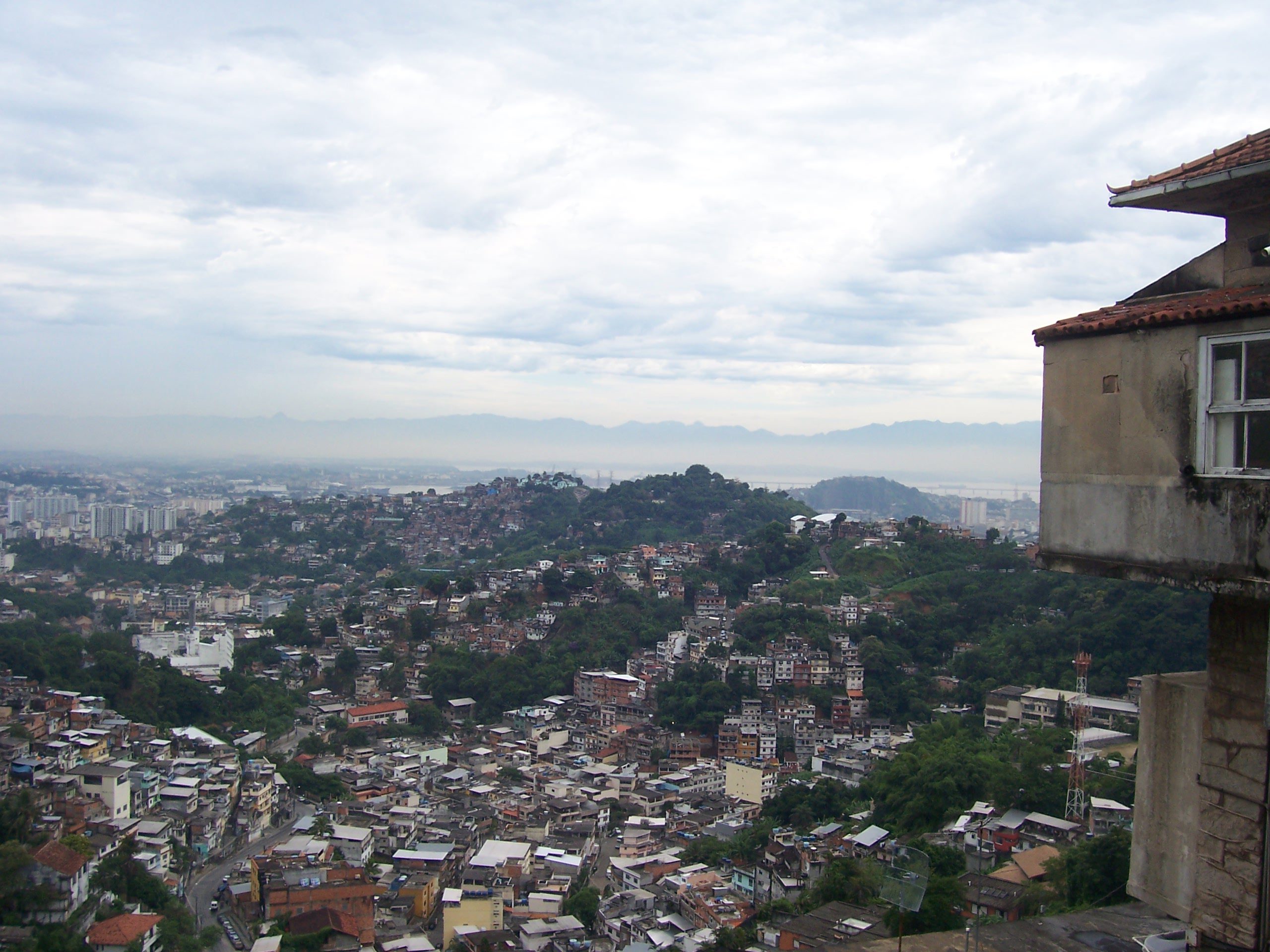 Panoramablick über dicht bebaute Hügel und Favelas von Rio de Janeiro bei bewölktem Himmel, Brasilien