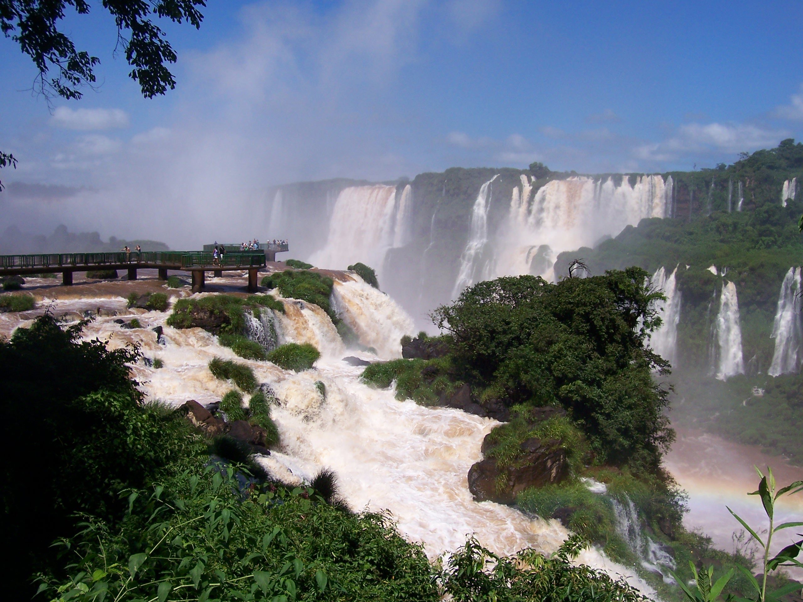 Besuchersteg vor der breiten Fallreihe der Iguaçu-Fälle mit aufsteigender Gischt, Brasilien