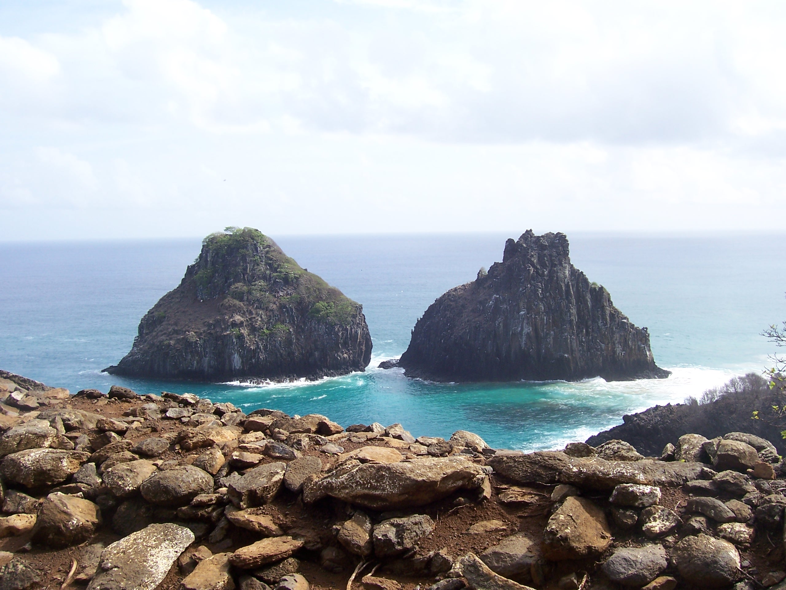 Die markanten Felsformationen Morro Dois Irmãos im türkisfarbenen Meer vor Fernando de Noronha, Brasilien
