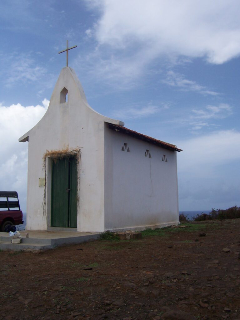 Kleine weiße Kapelle mit Kreuz und grüner Tür auf einem Hügel auf Fernando de Noronha, Brasilien