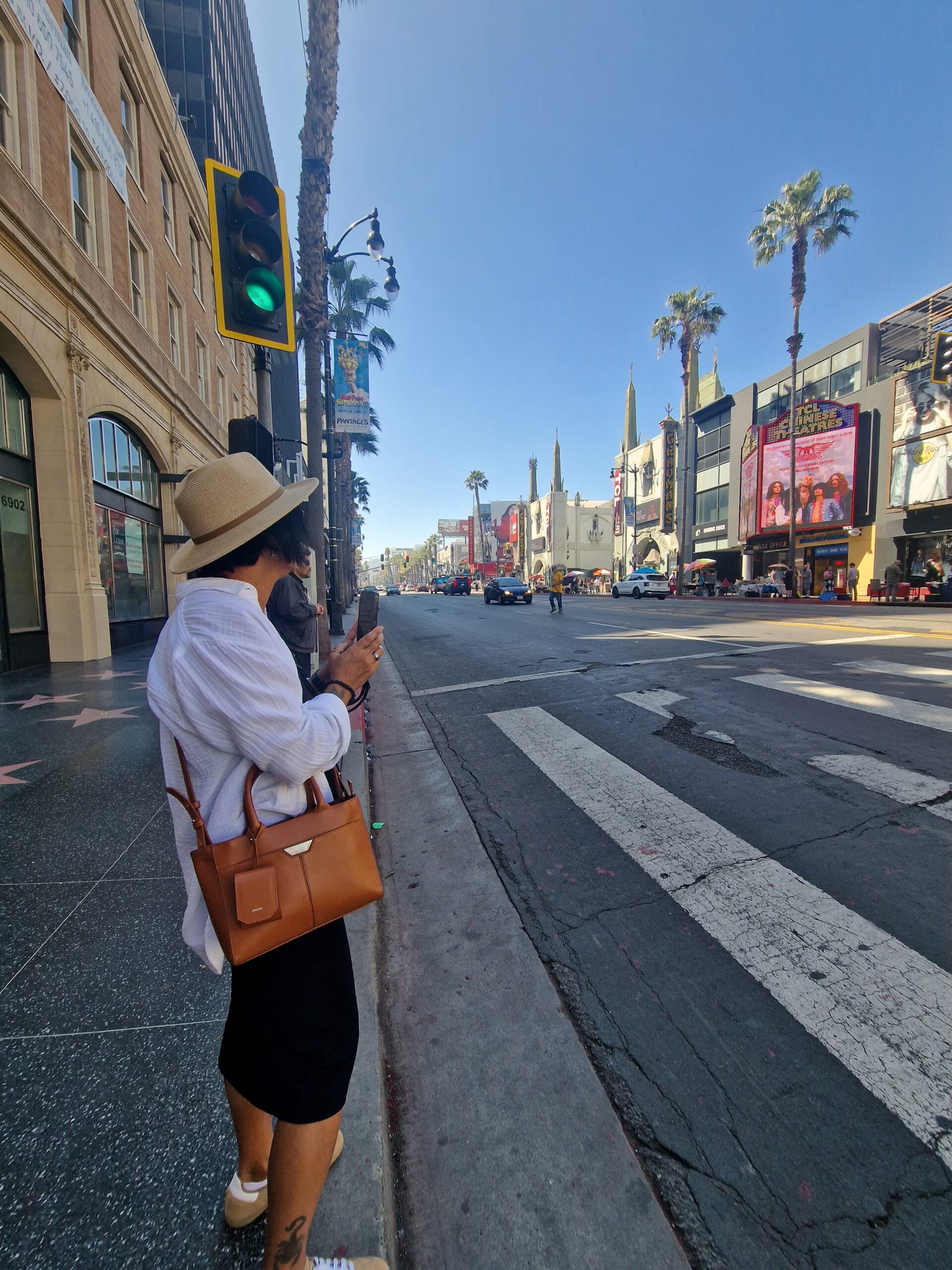 Frau mit Hut fotografiert den Hollywood Boulevard mit Blick auf das TCL Chinese Theatre