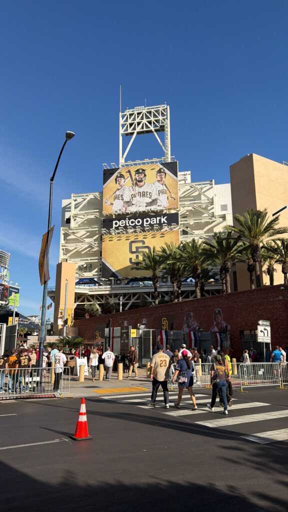 Eingang zum Petco Park in San Diego mit Padres-Werbetafel und Fans in Trikots vor dem Stadion