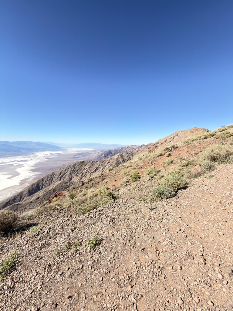 Schmaler Wanderpfad am Bergkamm mit Blick auf die Salzebene des Death Valley