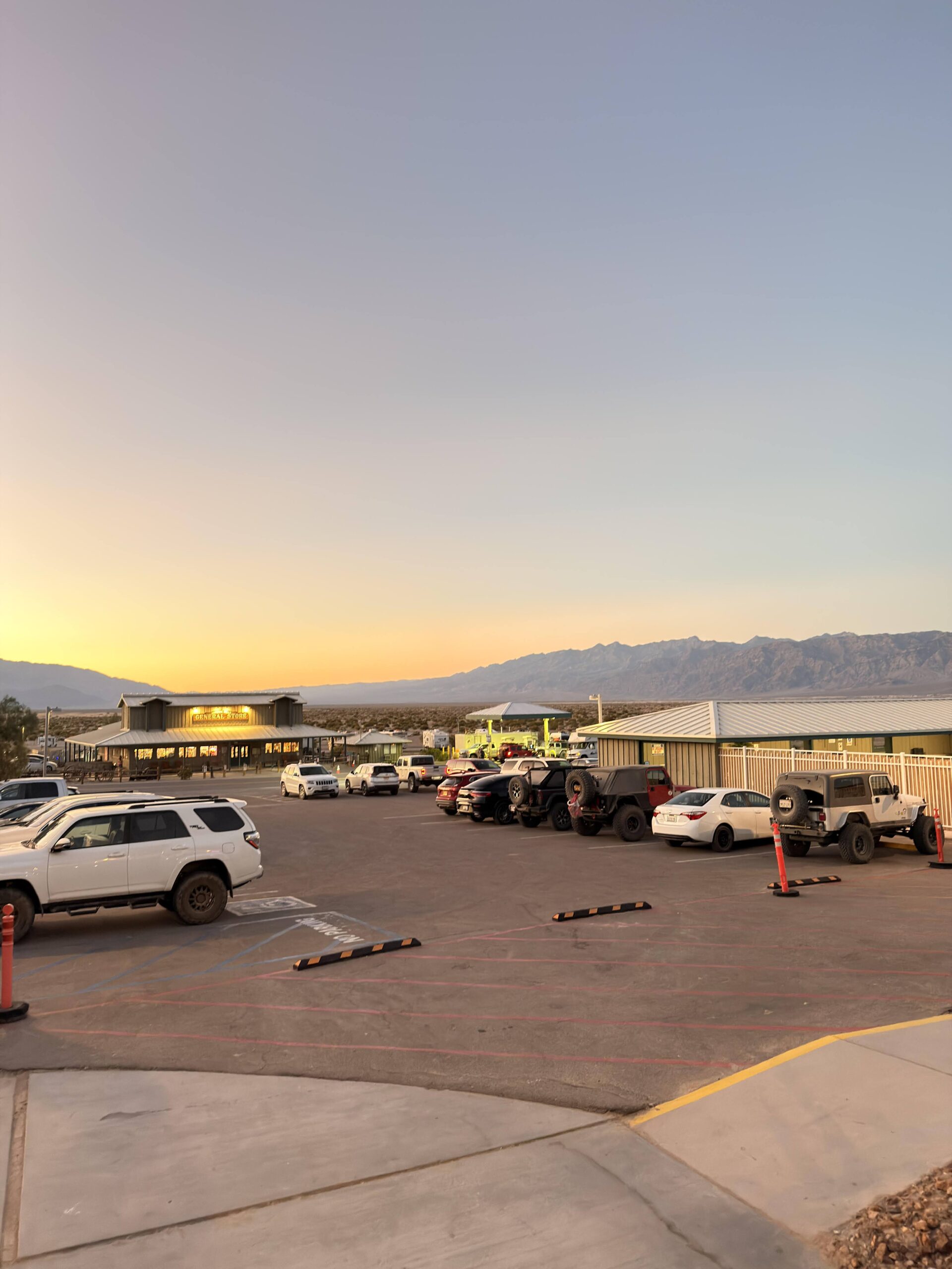 Parkplatz vor dem General Store von Stovepipe Wells bei Sonnenuntergang mit Geländewagen
