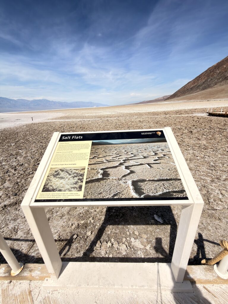 Infotafel "Salt Flats" am Badwater Basin mit Blick auf die weiße Salzkruste im Death Valley