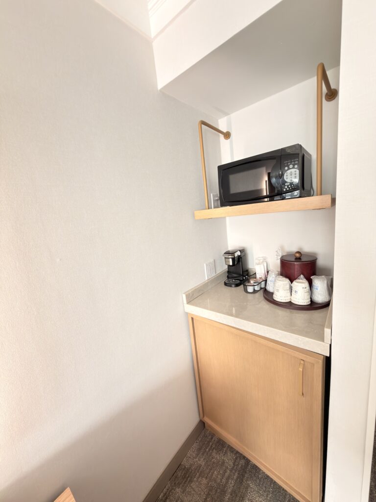 Kleine Kaffeestation mit Mikrowelle, Kaffeemaschine und Bechern im Hotelzimmer