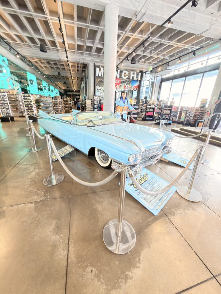 Hellblauer Vintage-Cadillac-Cabrio mit Elvis-Figur in einem Souvenirshop