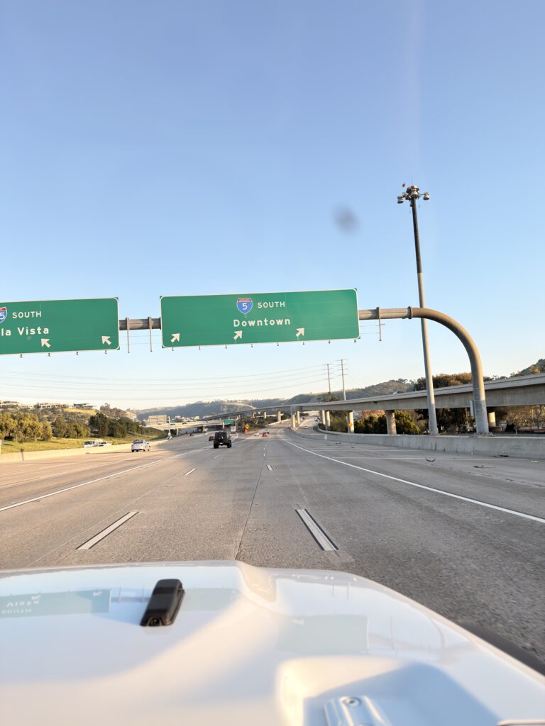 Blick durch die Windschutzscheibe auf die Interstate 5 South mit Hinweisschildern Richtung Downtown San Diego und Chula Vista