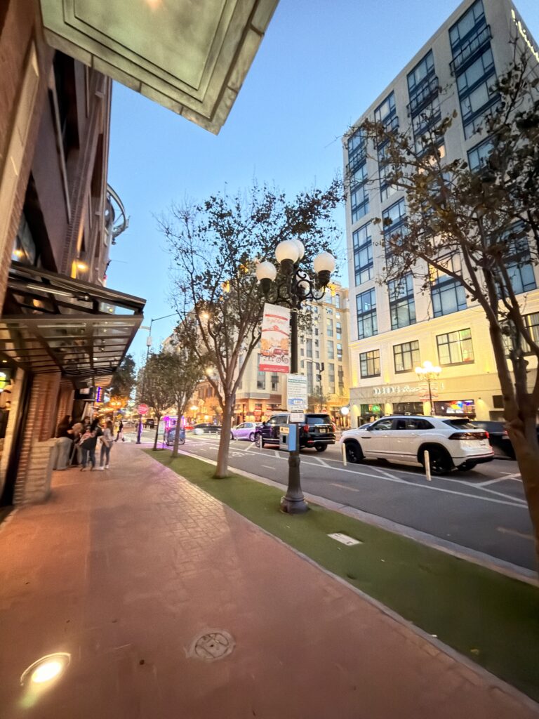 Straßenszene im Gaslamp Quarter San Diego in der Abenddämmerung mit Laternen und Hochhäusern