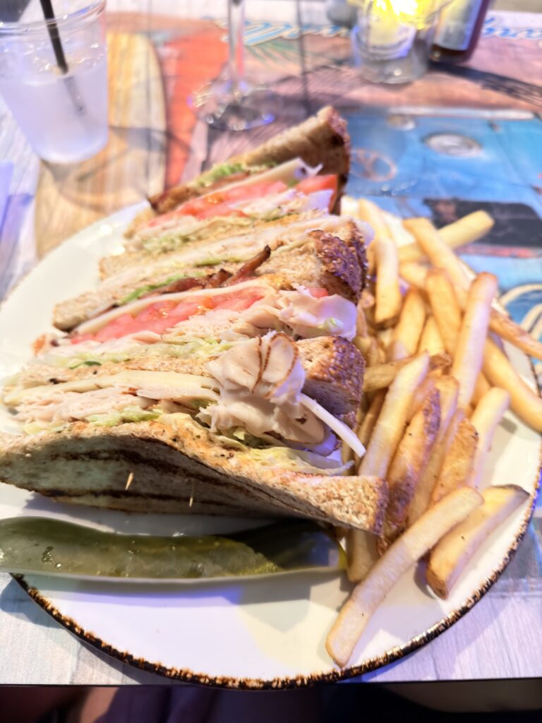 Club Sandwich mit Pute, Speck und Tomate serviert mit Pommes im Landshark Restaurant